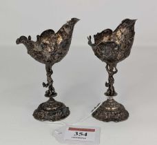 A pair of late 19th century continental white metal open salts, each having an embossed shell shaped