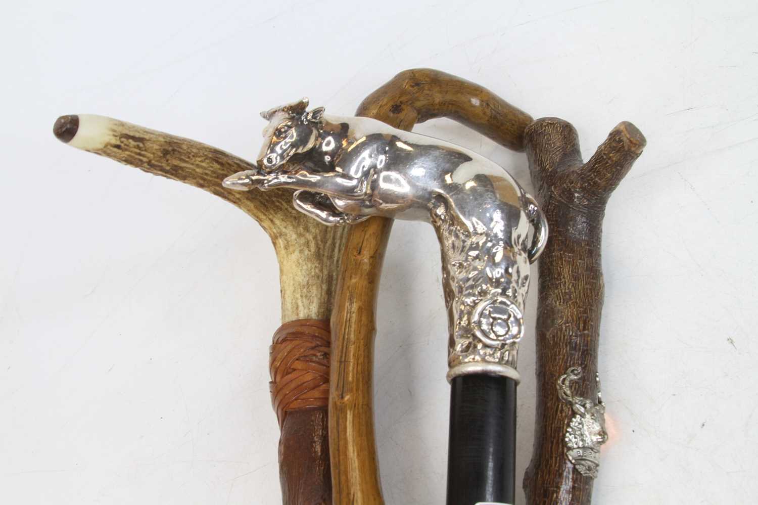 An ebonised walking stick, the filled silver handle in the form of a bull, length 93cm, together