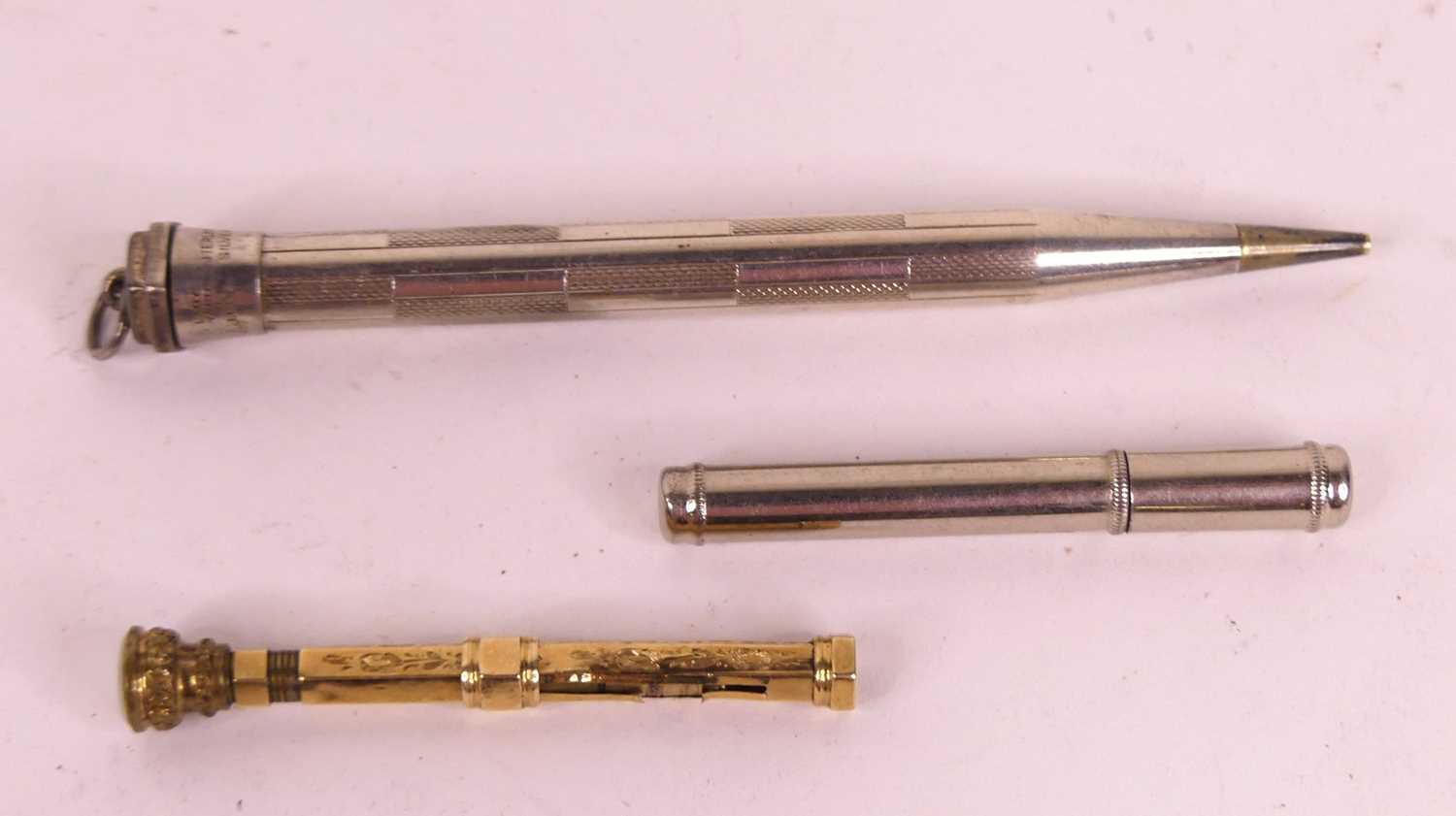 A gilt metal seal top propelling pencil, l.6cm, together with a white metal example stamped sterling