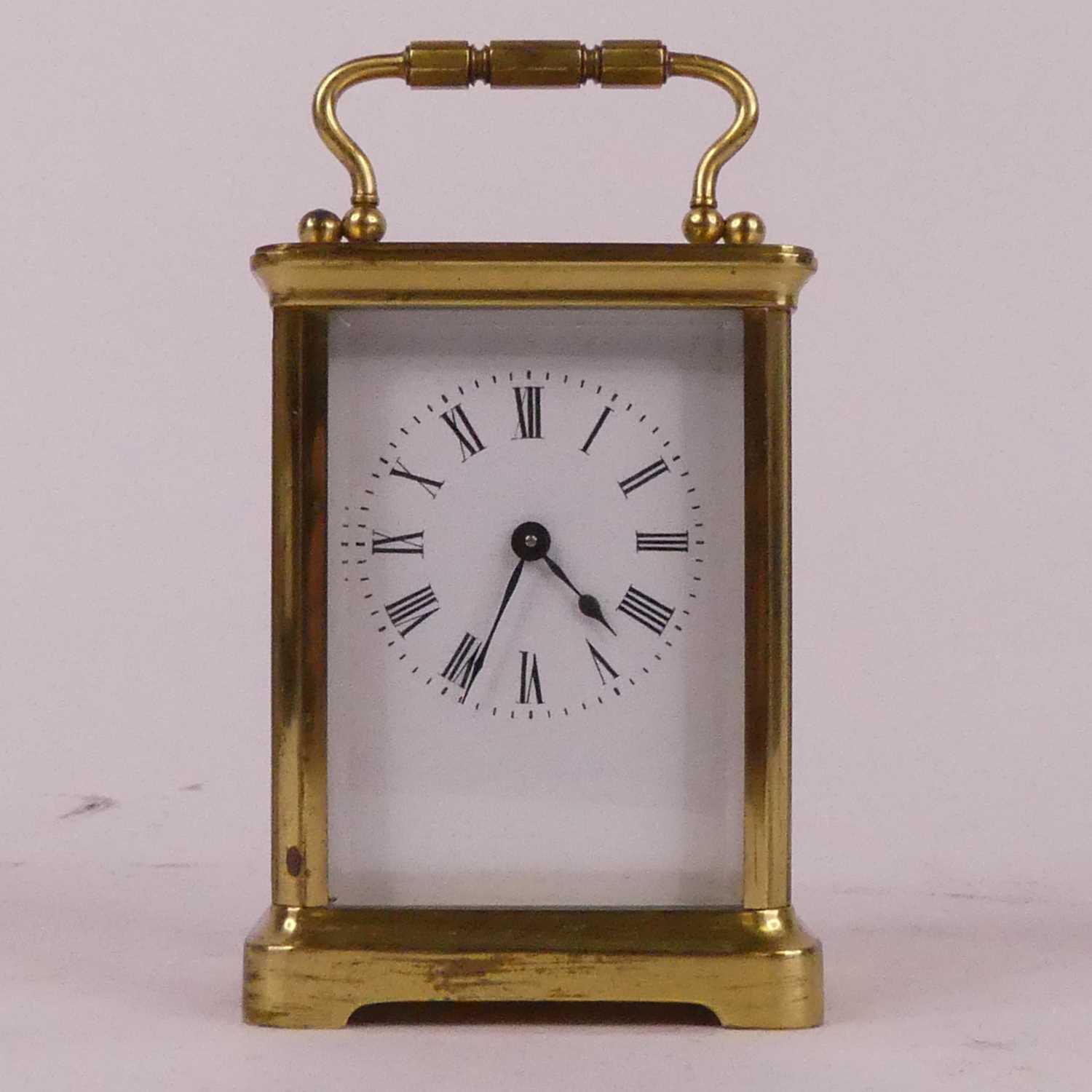 A lacquered brass carriage clock, the enamelled dial showing Roman numerals, having visible platform