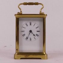 A lacquered brass carriage clock, the enamelled dial showing Roman numerals, having visible platform