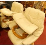 A pair of Stressless cream leather reclining armchairs, raised on formed laminate bases, each with