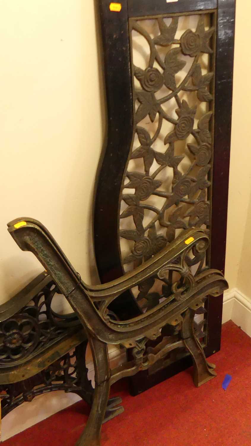 A cast metal two-seater garden bench (currently dismantled and lacking slatted seat section);