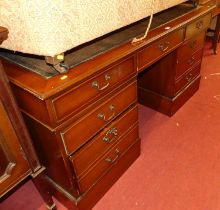 A contemporary mahogany and gilt tooled tan leather inset twin pedestal writing desk, having an