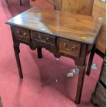 A George III mahogany three drawer lowboy, having a shaped apron and raised on moulded chamfered