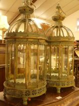 A pair of verdigris metal and glass inset domed hanging lanterns, each in the Eastern taste, h.59cm