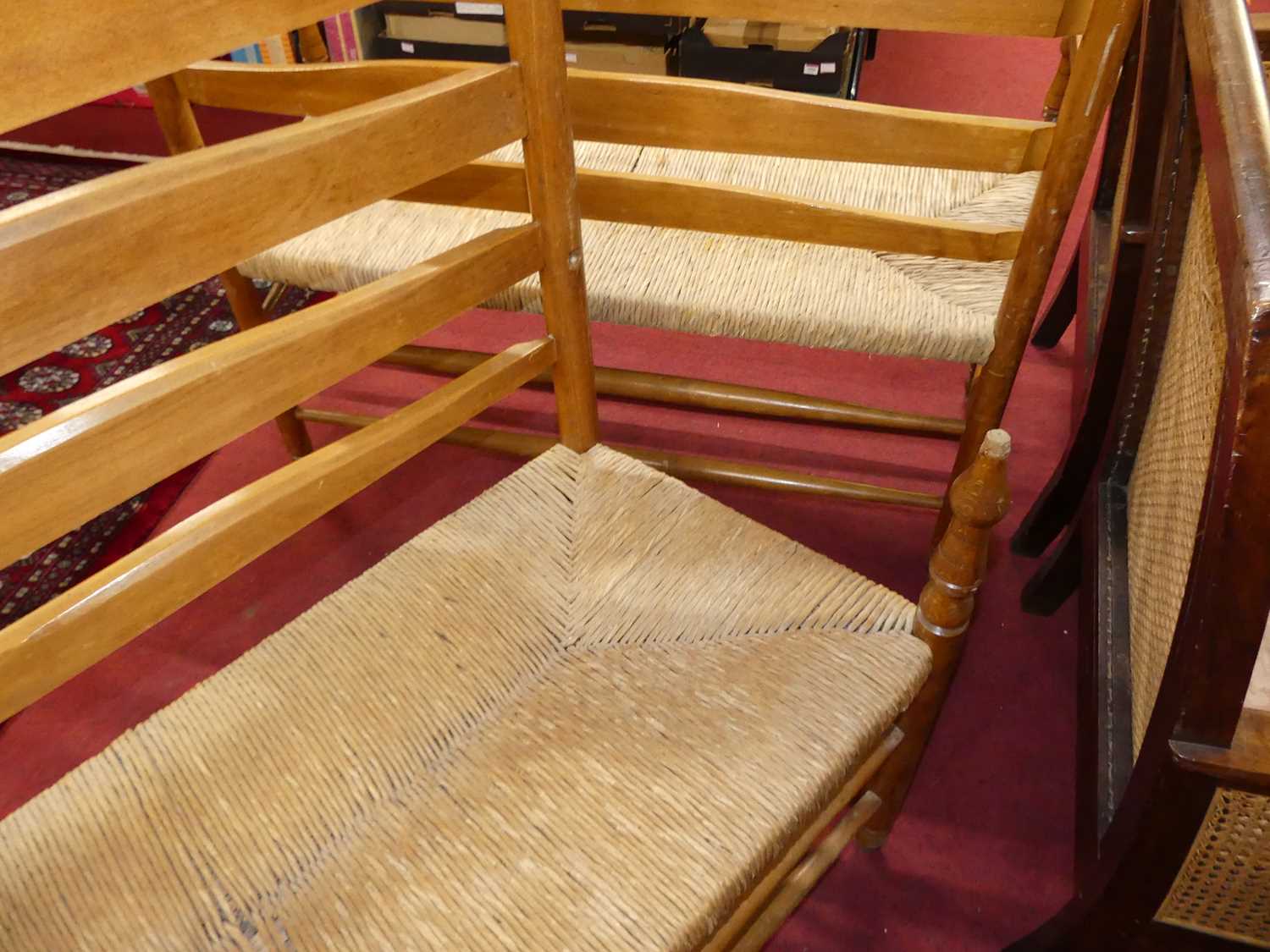 A set of four early 20th century elm and beech ladder back and rush seated two-seater settles, - Image 8 of 13