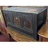 An 18th century joined oak three-panel hinge topped coffer, having later floral relief carved