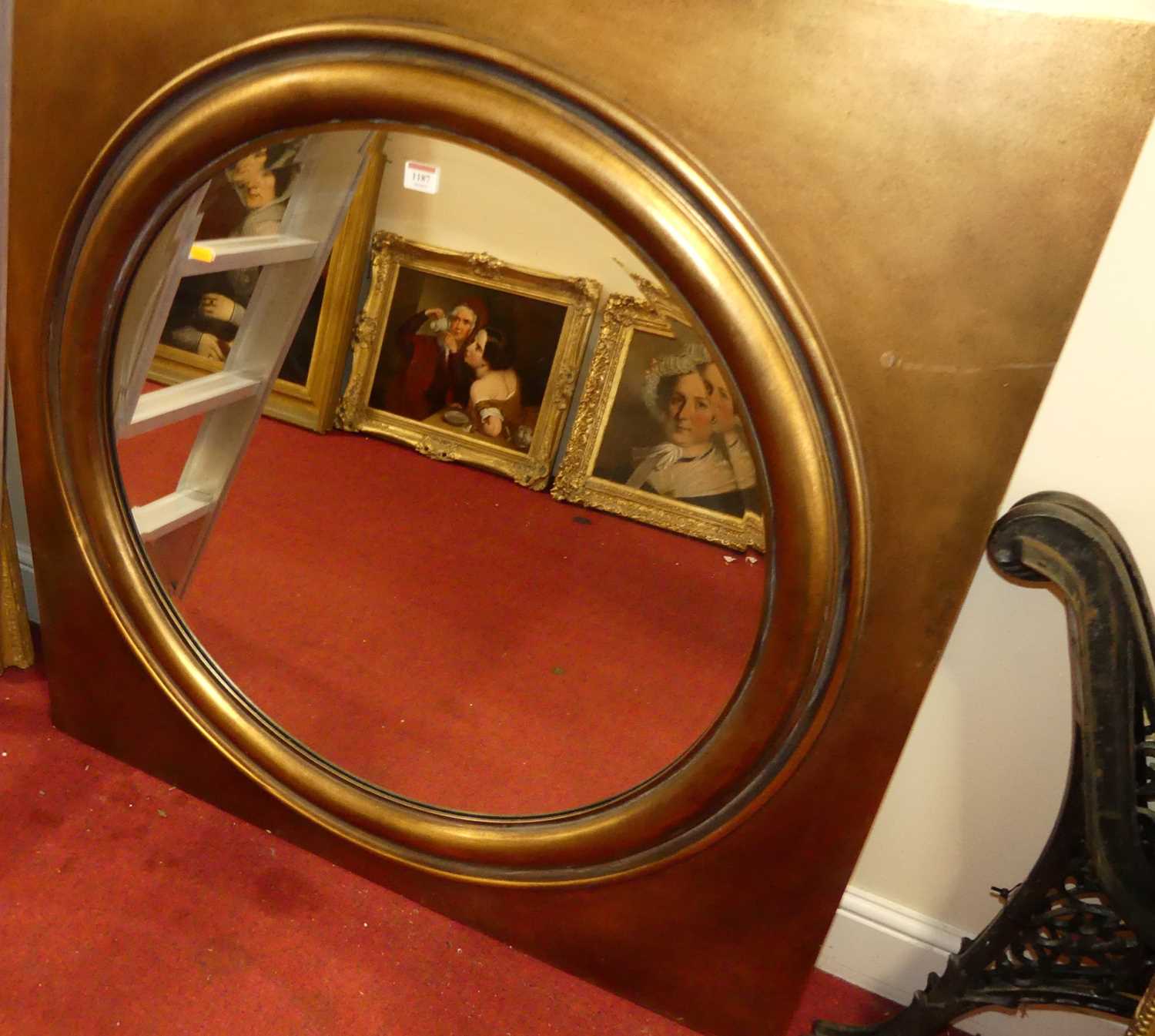 A contemporary gilt framed circular bevelled wall mirror, housed in a square frame with cushion