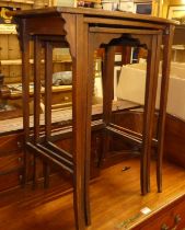 An early 20th century mahogany and chequer strung nest of three occasional tables, the largest w.
