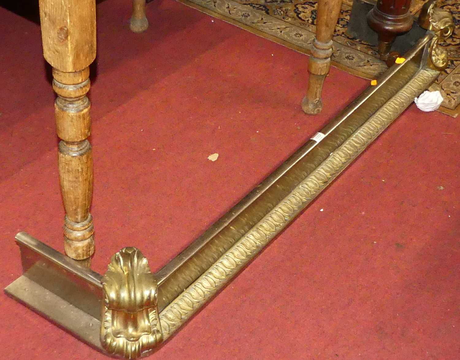 A 19th century steel and gilt brass fire fender in the classical taste, having floral scroll