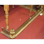 A 19th century steel and gilt brass fire fender in the classical taste, having floral scroll