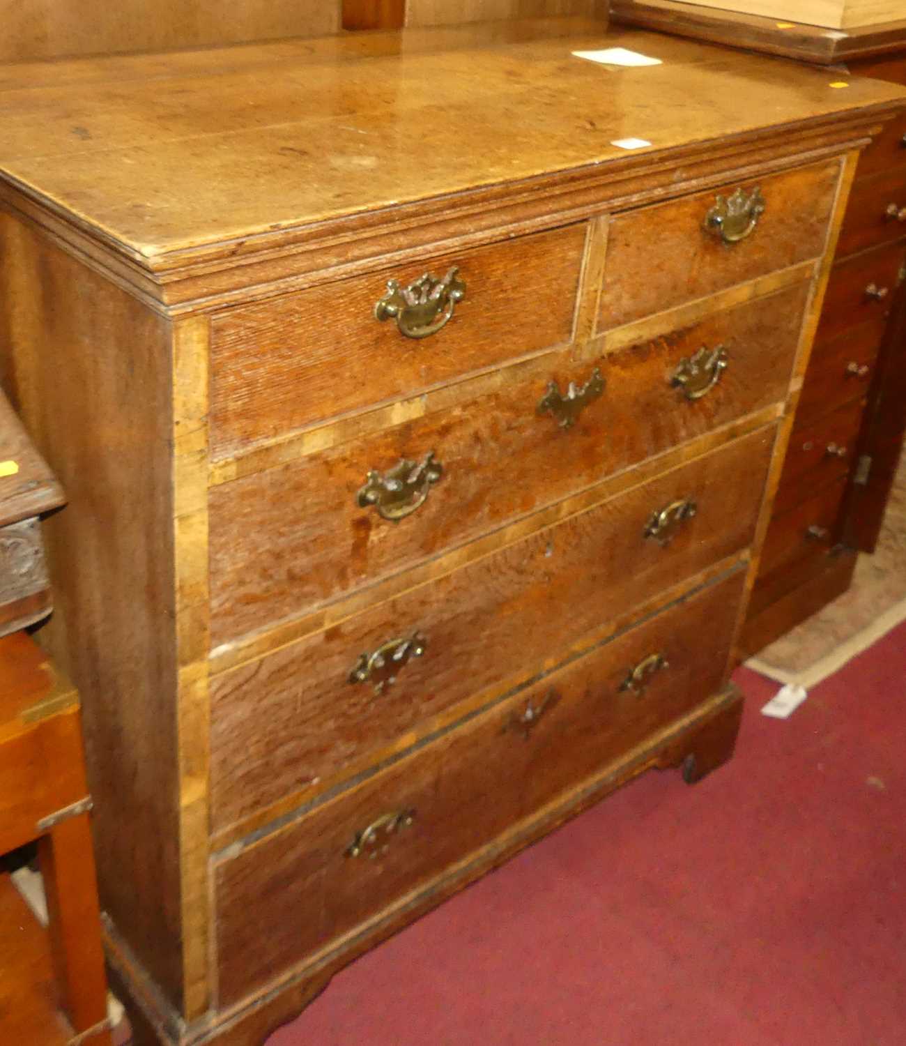 A George III oak squarefront chest of two short over three long graduated drawers, w.101cm