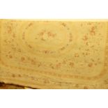 A Continental cream floral woven Aubusson rug Very faded. Some marks and light staining. Machine