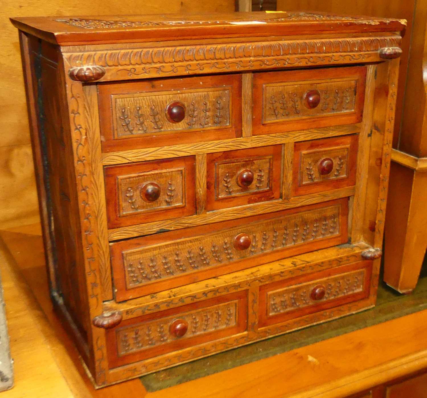 A South-East Asian stained softwood table-top chest, fitted with eight various drawers, w.37cm