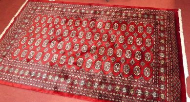 A Persian woollen red ground Bokhara rug, 242 x 154cm Rug is in excellent condition. Colours are