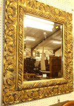 A contemporary Italian style floral gilt decorated deep cushioned bevelled rectangular wall