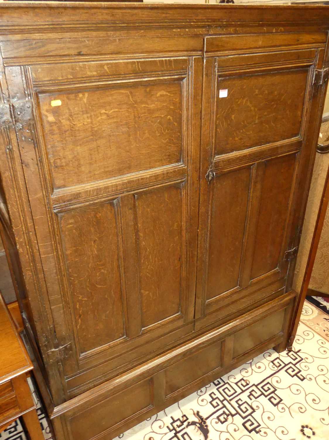 An antique joined oak double door panelled side cupboard, w.128cm