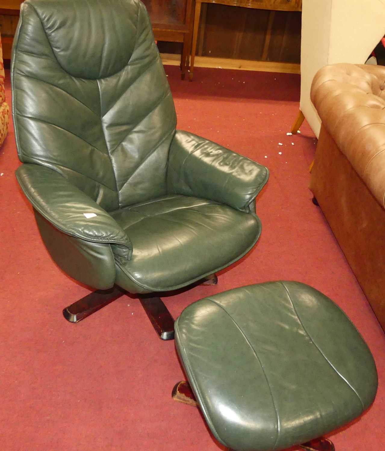 A contemporary green leather upholstered and formed laminate framed swivel armchair, with matching
