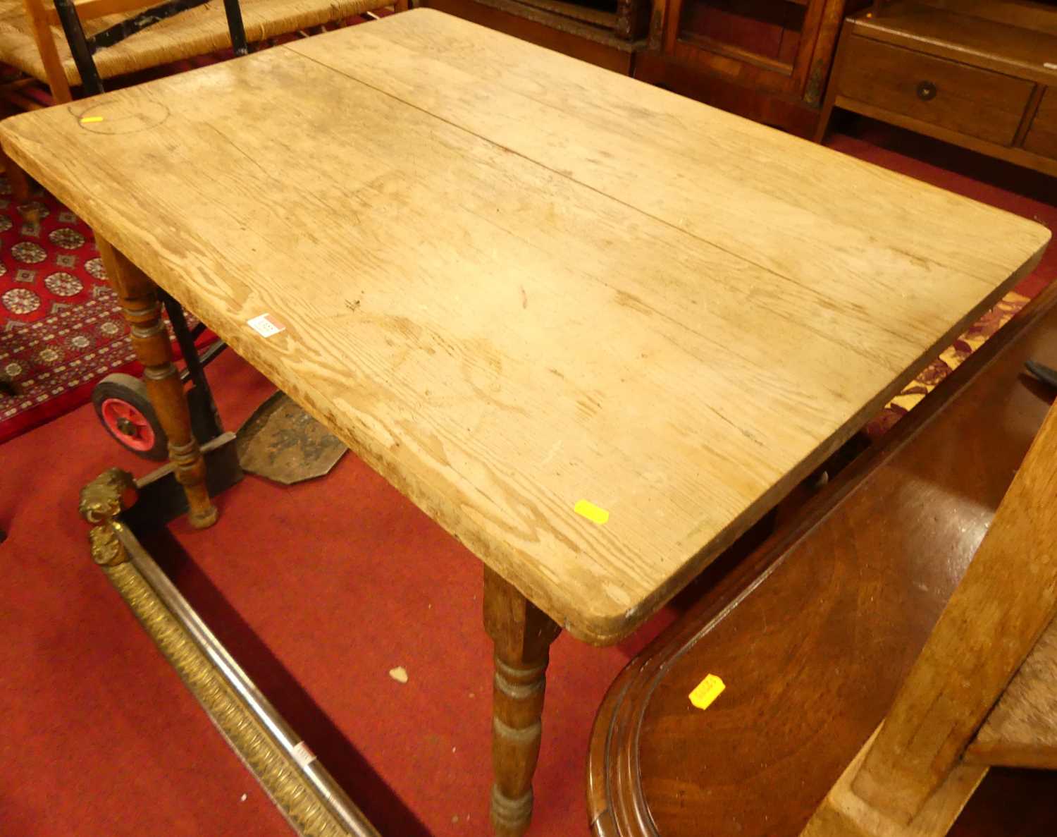 A rustic pine round cornered compact kitchen table, raised on turned supports, length 104.5cm