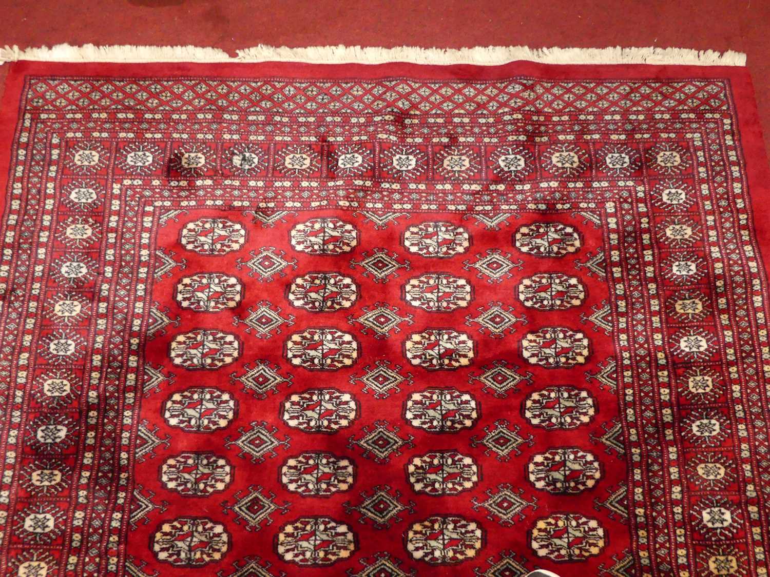 A Persian woollen red ground Bokhara rug, 242 x 154cm Rug is in excellent condition. Colours are - Image 3 of 4