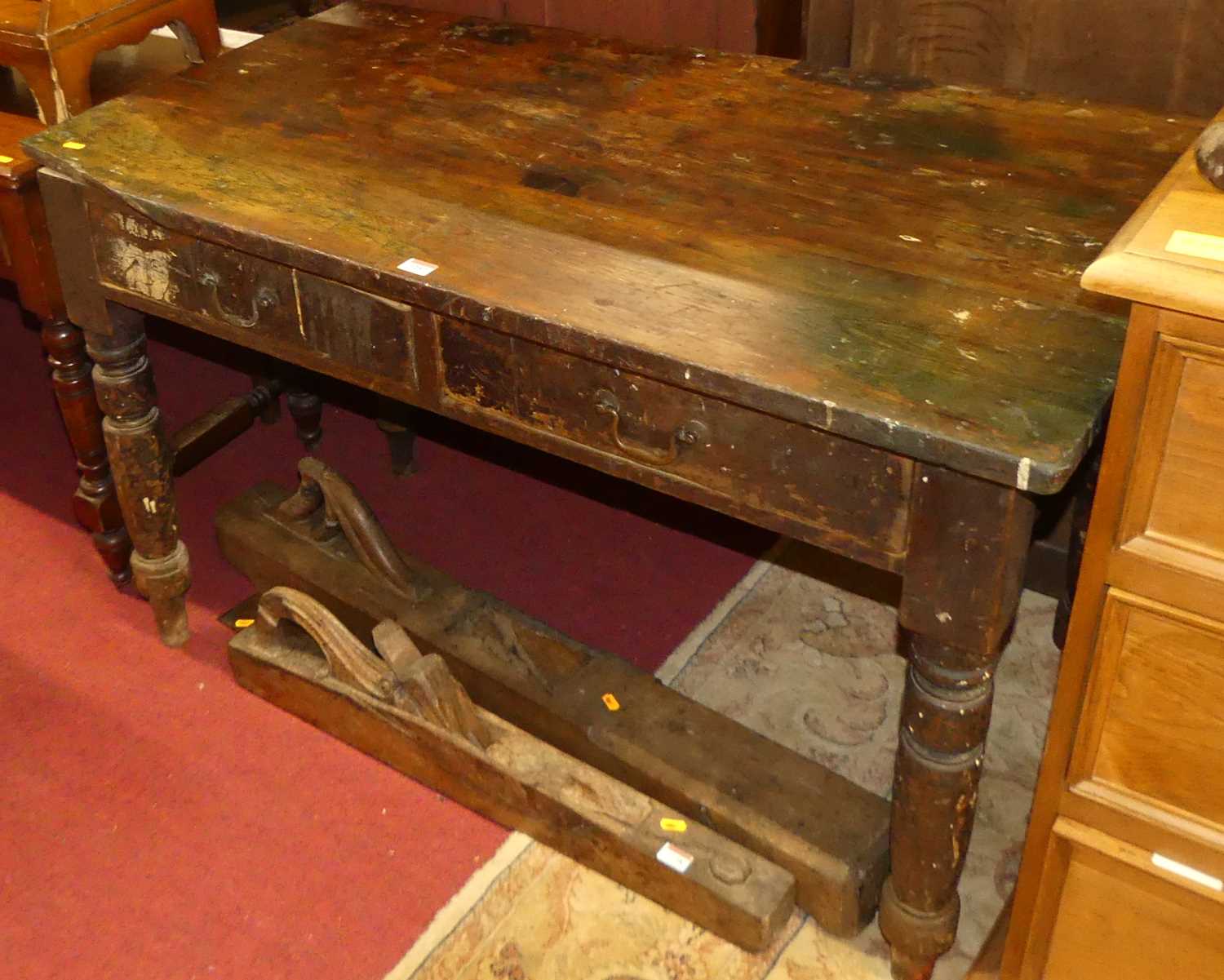 A rustic 19th century stained pine two drawer work table, on turned supports, w.117cm