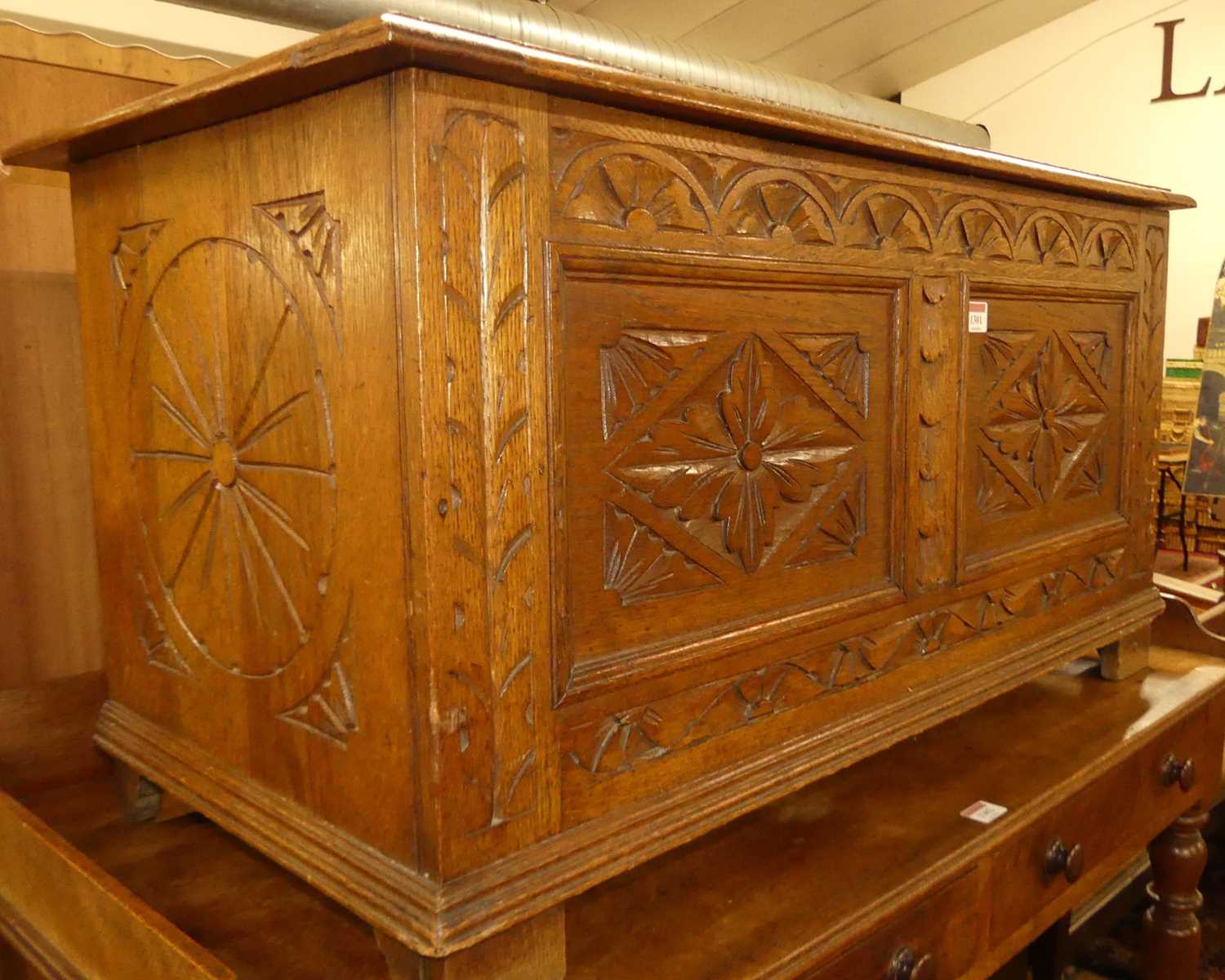 An Early 20th century floral relief and line carved oak two panelled hinge topped blanket chest, w.