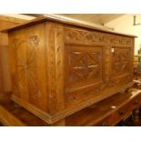 An Early 20th century floral relief and line carved oak two panelled hinge topped blanket chest, w.