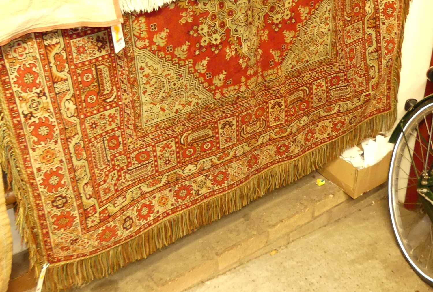 An Afghan red ground woollen table covering, having knotted and tasselled detail, 180 x 140cm