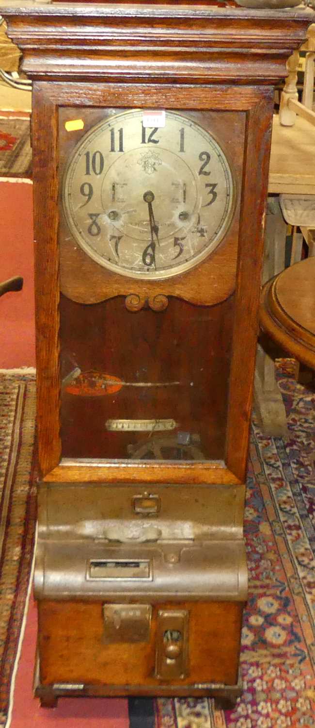 An early 20th century oak International Time Recording Co Ltd of London clocking-in and clocking-out