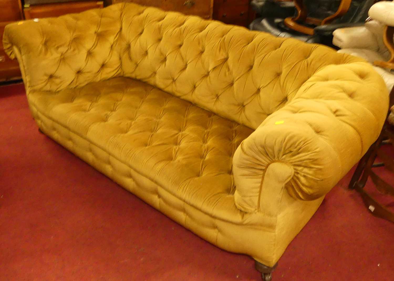 A circa 1900 and later mustard fabric button upholstered two-seater Chesterfield, raised on ring