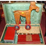 A suitcase containing a Kibri tin plate garage, a home made set of horse stables, a home made wooden