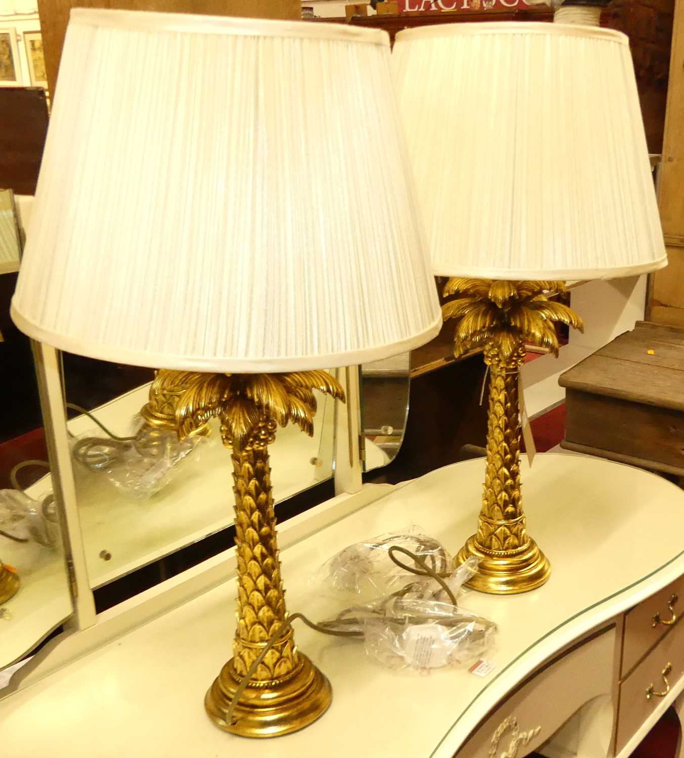 A pair of contemporary gilt table lamps, each in the form of a palm tree, with pleated silk