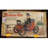 A tinplate battery operated antique car, with headlight and mystery action feature