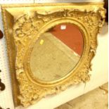 A 19th century floral giltwood and gesso decorated circular wall mirror, housed in a square frame,
