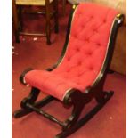 An ebonised and red fabric buttoned upholstered rocking nursing chair