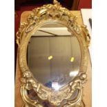 A gilt composition oval wall mirror, 20th century, 64 x 41cm; together with two others (3)