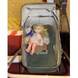 A vintage child's pram with a quantity of celluloid and plastic dolls