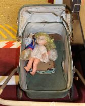 A vintage child's pram with a quantity of celluloid and plastic dolls