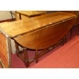 A contemporary joined oak dropleaf wake table, having opposing double gateleg action, raised on