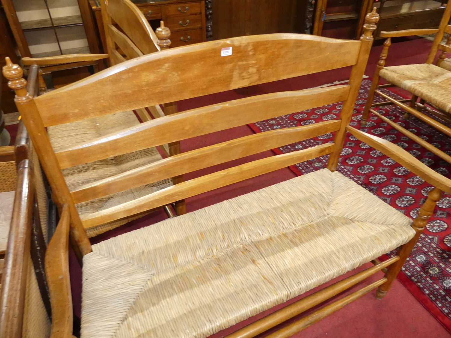 A set of four early 20th century elm and beech ladder back and rush seated two-seater settles, - Image 4 of 13