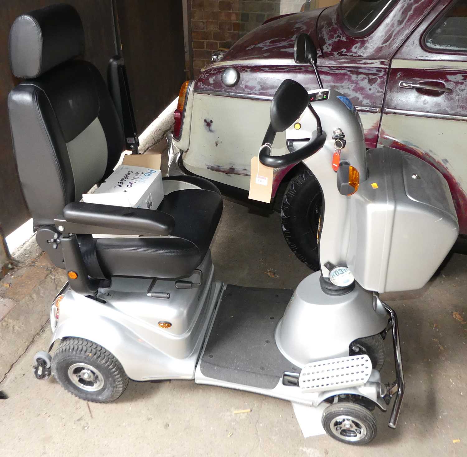 A Quingo Plus battery powered mobility scooter, with key and charging pack