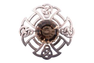 A Scottish Celtic influenced silver plaid brooch, having a 20 mm yellow heliodor set on a roundel of