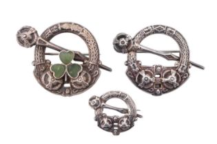 Three 1920s silver kilt-pin brooches, including one having a polished hardstone shamrock, 13.56 g