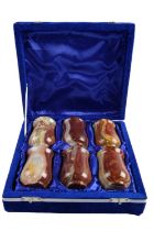 A cased set of six onyx beakers, 7 cm