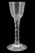 A George III facet-cut wine glass, having an ogee bowl with panelled and cut base and traces of gilt
