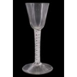 A mid 18th Century opaque twist wine glass, having a conical funnel bowl, the stem having gauze tube