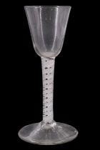 A mid 18th Century opaque twist wine glass, having a conical funnel bowl, the stem having gauze tube