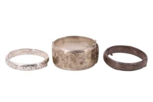 Three silver bangles, all of D-section and decorated with engraved foliate scrolls, largest 32 mm,
