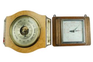 A 1960s birdseye maple aneroid barometer by O Comitti of London, having a thermometer and storm